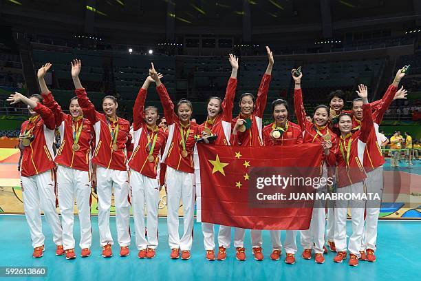 Gold medallists China pose on the podium with a flag after the women's Gold Medal volleyball match at Maracanazinho Stadium in Rio de Janeiro on...
