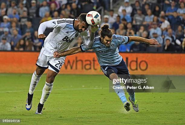 Forward Giles Barnes of the Vancouver Whitecaps FC heads a shot on goal against mid-fielder Graham Zusi of Sporting Kansas City during the first half...