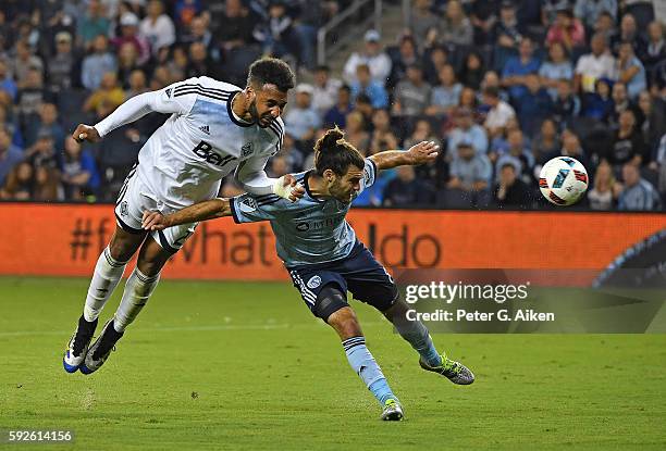 Forward Giles Barnes of the Vancouver Whitecaps FC heads a shot on goal against mid-fielder Graham Zusi of Sporting Kansas City during the first half...