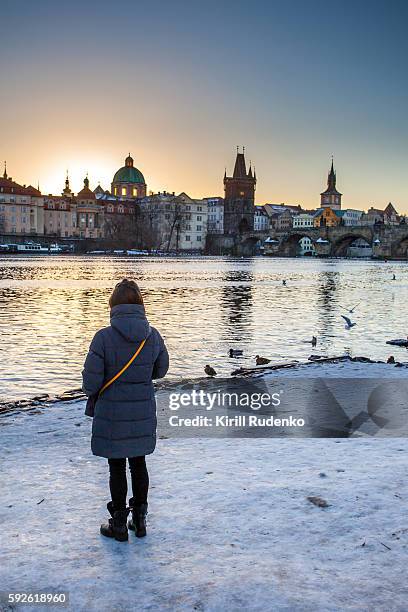 woman observing sunrise over central prague, czech republic - prague river stock pictures, royalty-free photos & images