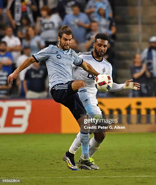 Mid-fielder Graham Zusi of Sporting Kansas City battles for the ball against forward Giles Barnes of the Vancouver Whitecaps FC during the second...