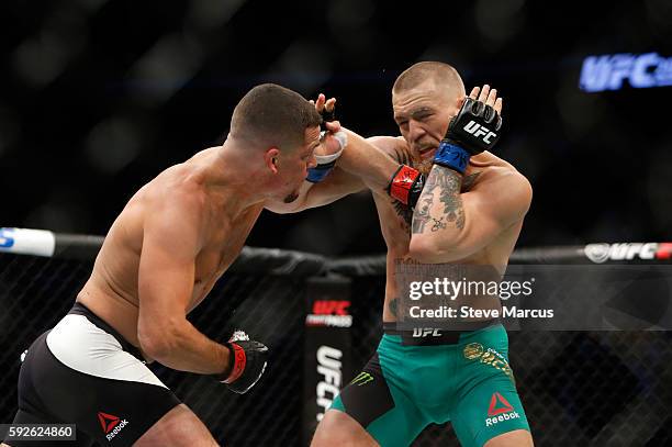 Conor McGregor takes a punch from Nate Diaz during their welterweight rematch at the UFC 202 event at T-Mobile Arena on August 20, 2016 in Las Vegas,...