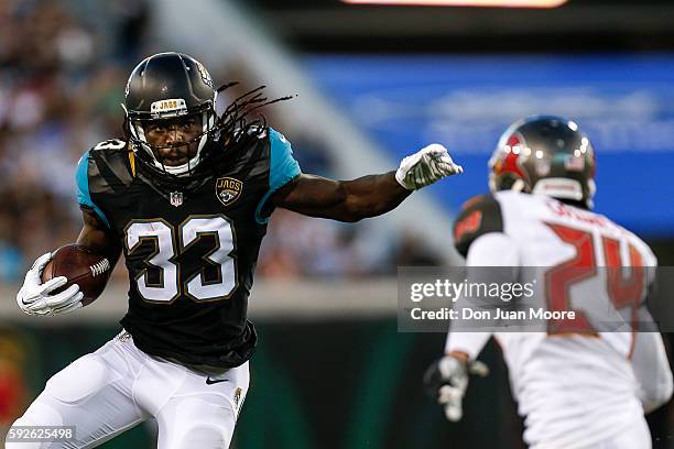 Runningback Chris Ivory of the Jacksonville Jaguars avoids a tackle by Cornerback Brent Grimes of the Tampa Bay Buccaneers during a preseason game at...