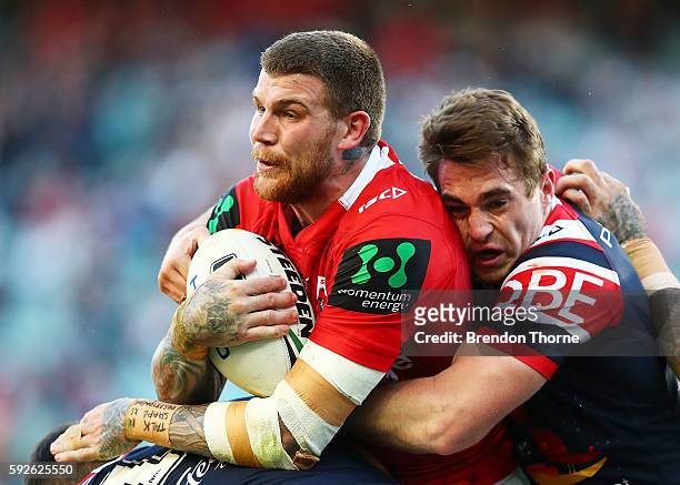 Josh Dugan of the Dragons is tackled by Roosters defence during the round 24 NRL match between the Sydney Roosters and the St George Illawarra...