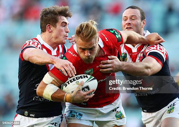 Jack De Belin of the Dragons is tackled by Roosters defence during the round 24 NRL match between the Sydney Roosters and the St George Illawarra...