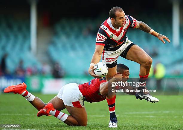 Blake Ferguson of the Roosters is tackled by Taane Milne of the Dragons during the round 24 NRL match between the Sydney Roosters and the St George...