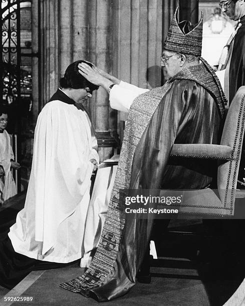 The Archbishop of Canterbury, Reverend Robert Runcie, ordains the first woman priests in Canterbury Cathedral, April 1987.