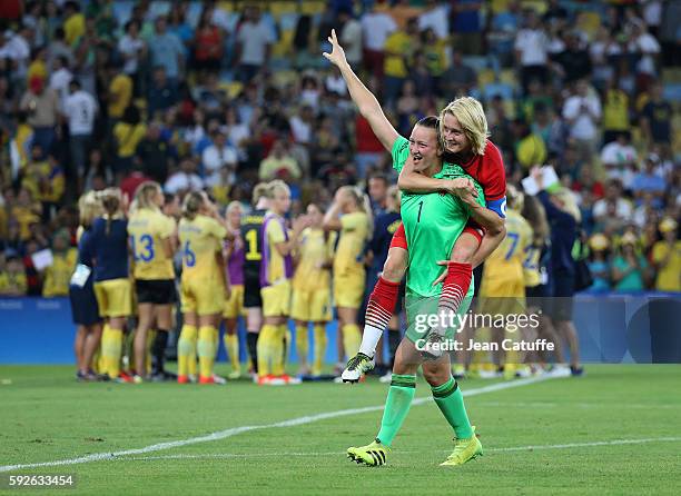 Saskia Bartusiak and goalkeeper of Germany Almuth Schult of Germany celebrate winning the gold medal in the Women's Soccer Final between Germany and...