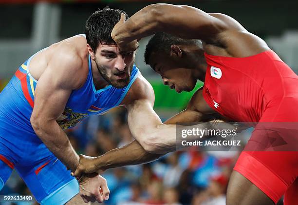 Italy's Frank Chamizo Marquez wrestles with Armenia's Devid Safaryan in their men's 65kg freestyle round of 16 match on August 21 during the...