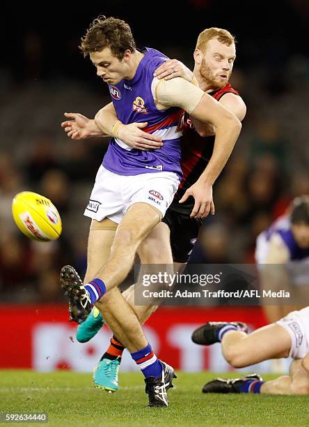 Zaine Cordy of the Bulldogs is tackled by Adam Cooney of the Bombers playing his 250th and final game during the 2016 AFL Round 22 match between the...