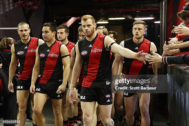 Mathew Stokes of the Bombers and Adam Cooney of the Bombers lead their team onto the field during the round 22 AFL match between the Essendon Bombers...