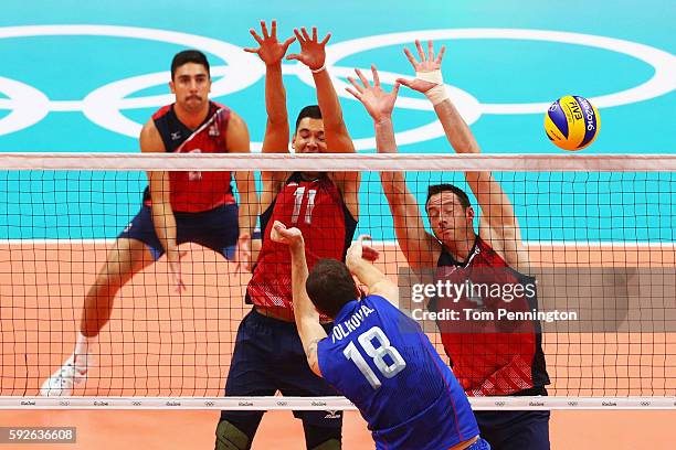 Micah Christenson of United States and David Lee of United States block the spike of Alexander Volkov of Russia during the Men's Bronze Medal Match...