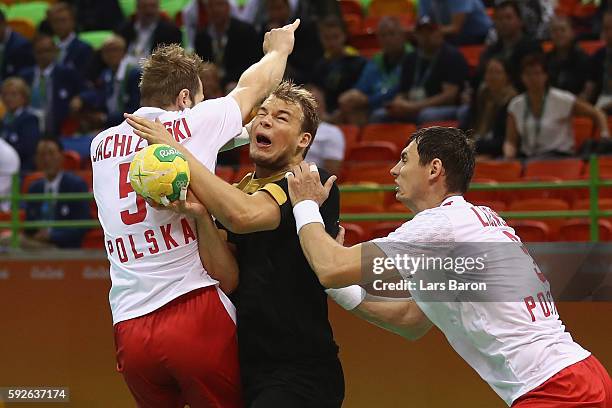 Paul Drux of Germany is blocked by Mateusz Jachlewski of Poland and Krzysztof Lijewski of Poland during the Men's Bronze Medal Match between Poland...