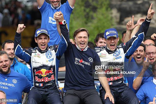 French driver Sebastien Ogier and his co-pilot Julien Ingrassia sit next to Volkswagen motorsport manager Jost Capito as they celebrate their victory...