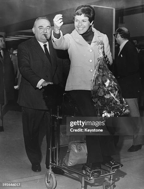 Singer Elis Regina being pushed along on a luggage trolley by Bruno Coquatrix, owner and manager of the Paris Olympia Music Hall, France, circa 1970.