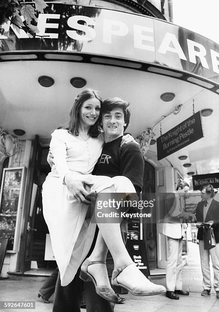 Actor Roger Rees lifting up actress Emily Richards in his arms outside the Aldwych Theatre, promoting their Royal Shakespeare production of 'The Life...