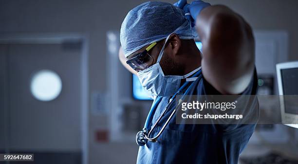 protecting his patient and himself from germs - medical scrubs bildbanksfoton och bilder
