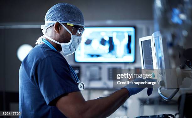 surveiller avec vigilance les signes vitaux de son patient - doctor stock photos et images de collection