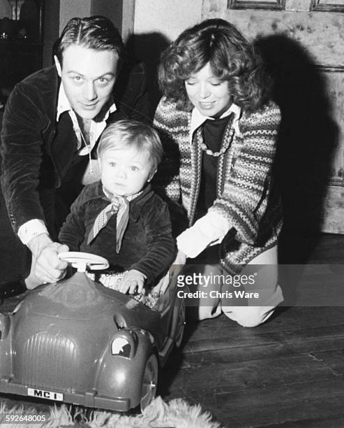Actors and spouses Christopher Cazenove and Angharad Rees playing with their young son Linford in a toy car, at their home in South London, circa...