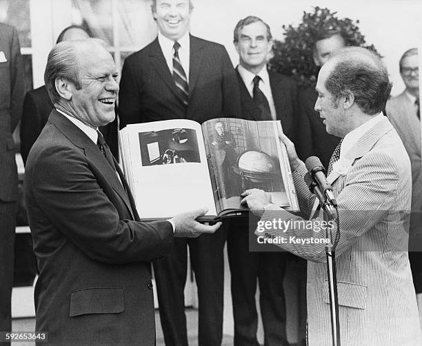 Canadian Prime Minister Pierre Trudeau presenting a Bicentennial gift to US President Gerald Ford, in the Rose Garden of the White House, Washington...