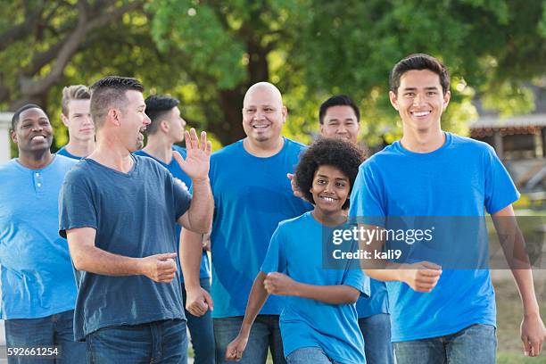 multi-ethnic group of fathers and sons walking together - kids marching stock pictures, royalty-free photos & images