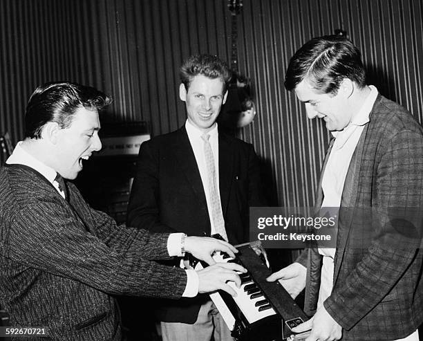 Musicians of the band 'The John Barry Seven'; Les Reed, Vic Flick and Mike Peters, playing around with a Univox portable keyboard at the 'Room at the...