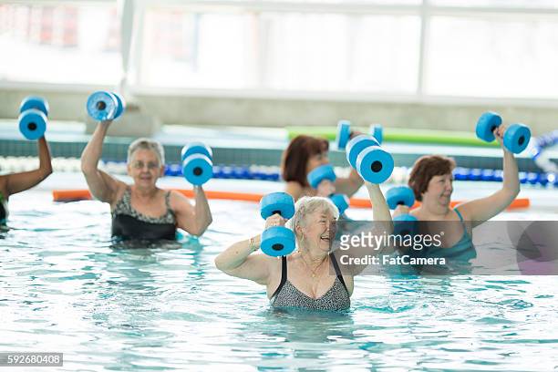 senioren bei einem wassergymnastikkurs am pool - aquarobics stock-fotos und bilder