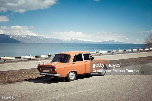 old orange car near sevan lake in armenia - tinted window stock pictures, royalty-free photos & images