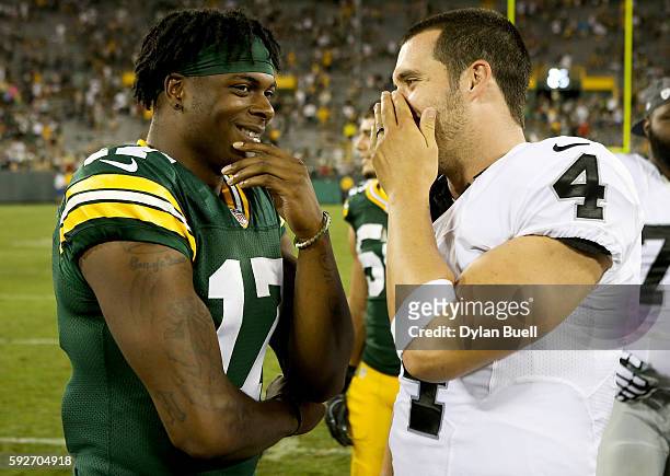 Davante Adams of the Green Bay Packers and Derek Carr of the Oakland Raiders chat after the preseason game at Lambeau Field on August 18, 2016 in...