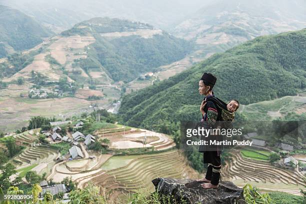 woman of the black hmong hill tribe carrying baby on her back - minorité miao photos et images de collection