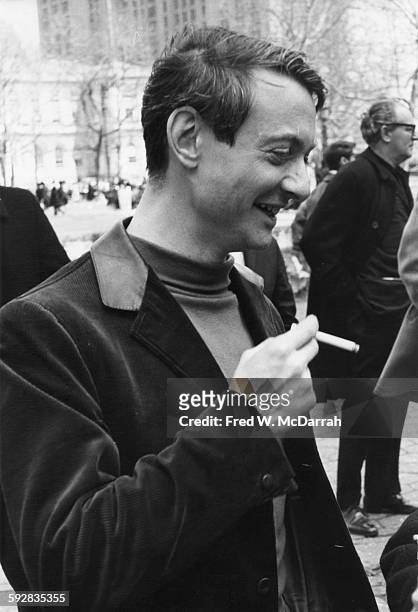 American Pop artist Roy Lichtenstein smokes a cigarette as he attends the March on City Hall to Save Artists Lofts, New York, New York, April 3, 1964.