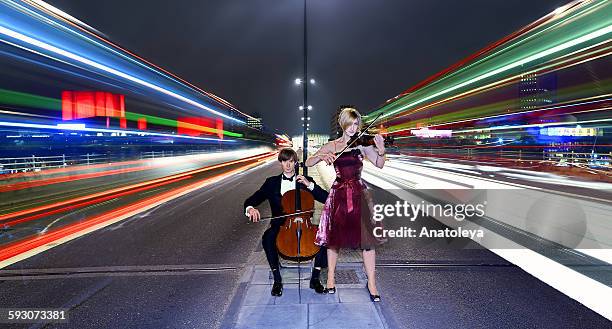 violinist and cellist performing in traffic - beautiful woman violinist stock pictures, royalty-free photos & images