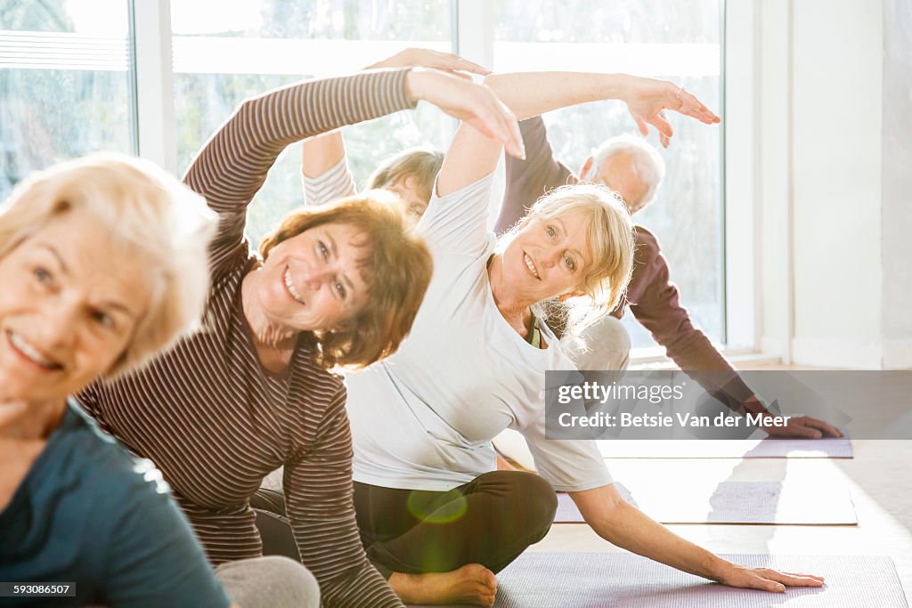 Group of active seniors exercise in yoga class.