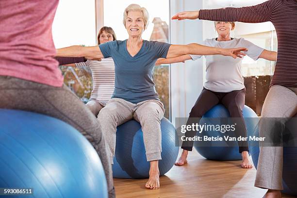 group of seniors sitting on exercise balls. - yoga ball work stock pictures, royalty-free photos & images