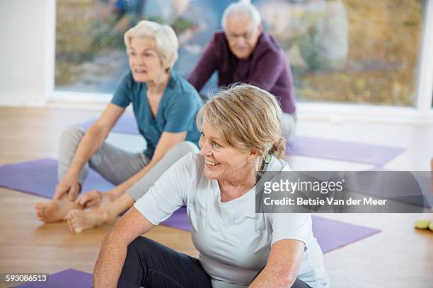 group of seniors sitting in yoga class. - senior yoga stock pictures, royalty-free photos & images