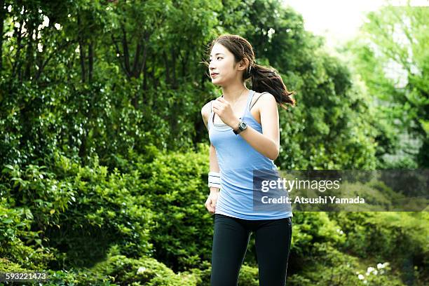 young woman jogging in park - tank top stock pictures, royalty-free photos & images