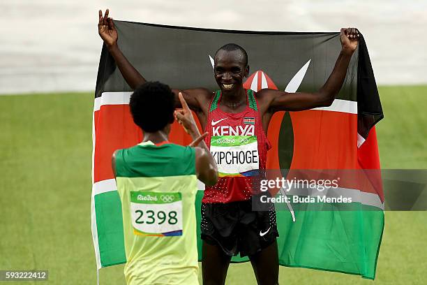 Eliud Kipchoge of Kenya celebrates as he wins gold with silver medalist Feyisa Lilesa of Ethiopia during the Men's Marathon on Day 16 of the Rio 2016...