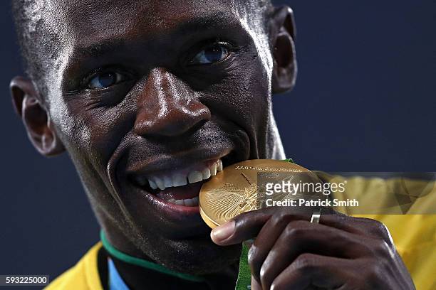 Gold medalist Usain Bolt of Jamaica bites his gold medal during the medal ceremony for the Men's 4 x 100 meter Relay on Day 15 of the Rio 2016...