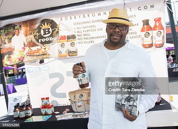 Author/singer Bobby Brown holds his new book and sauce from Bobby Brown Foods at the Leimert Park Village Book Fair at Baldwin Hills Crenshaw Plaza...
