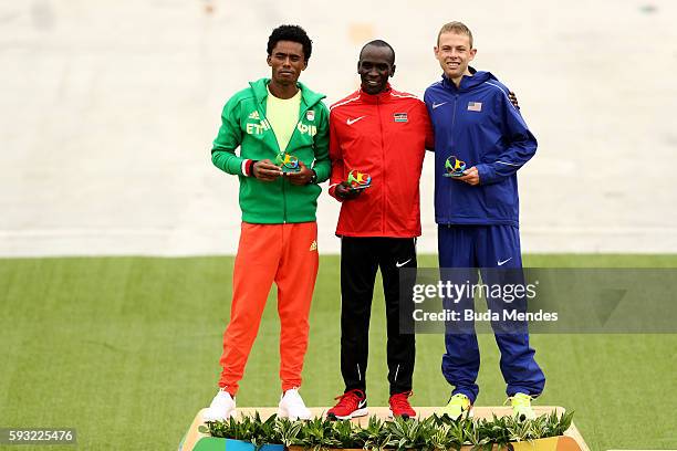 Silver medalist Feyisa Lilesa of Ethiopia, gold medalist Eliud Kipchoge of Kenya and bronze medalist Galen Rupp of the United States celebrate on the...