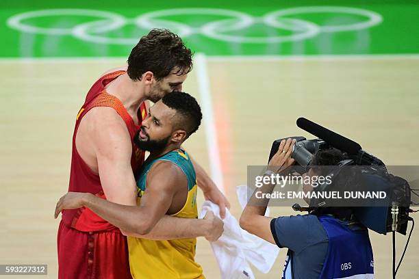 Spain's centre Pau Gasol embraces Australia's guard Patty Mills after Spain defeated Australia during a Men's Bronze medal basketball match between...