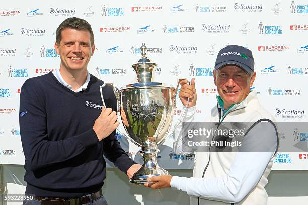 Paul Eales of England is presented with the trophy by Alan Grant, Senior Golf Manager, Event Scotland after the final round of the Prostate Cancer UK...