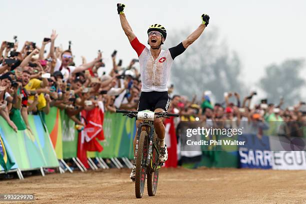 Nino Schurter of Switzerland celebrates winning gold during the Men's Cross-Country on Day 16 of the Rio 2016 Olympic Games at Mountain Bike Centre...