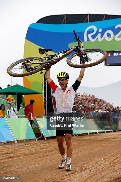 Nino Schurter of Switzerland celebrates winning gold during the Men's Cross-Country on Day 16 of the Rio 2016 Olympic Games at Mountain Bike Centre...