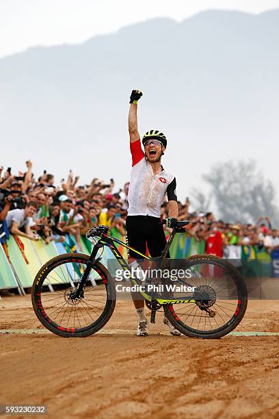 Nino Schurter of Switzerland celebrates winning gold during the Men's Cross-Country on Day 16 of the Rio 2016 Olympic Games at Mountain Bike Centre...