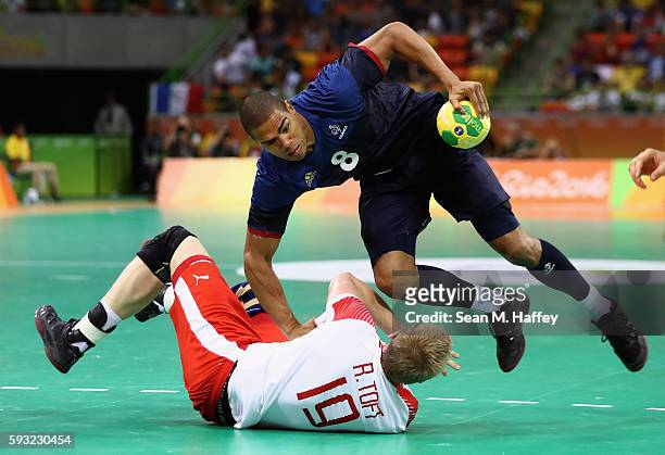 Daniel Narcisse of France handles the ball against Rene Toft Hansen of Denmark during the first half in the Men's Gold Medal Match between Denmark...