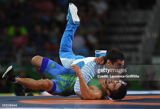 Ikhtiyor Navruzov of Uzbekistan and coach celebrate after winning the bronze in the Men's Freestyle 65kg Bronze match against Mandakhnaran Ganzorig...