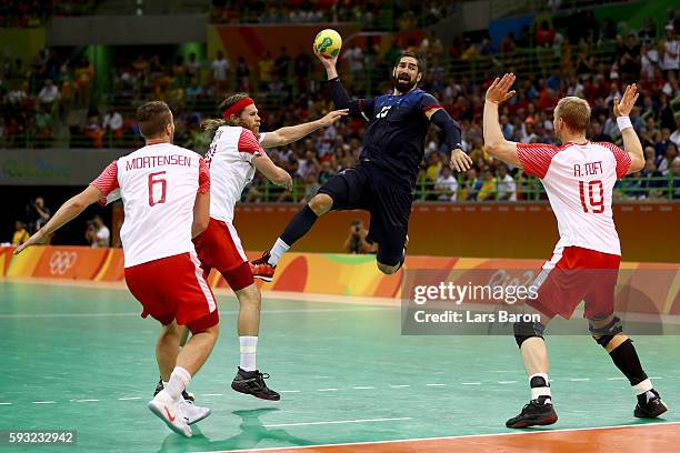 Nikola Karabatic of France jumps to shoot against Mikkel Hansen, Rene Toft Hansen and Casper Mortensen of Denmark during the Men's Gold Medal Match...