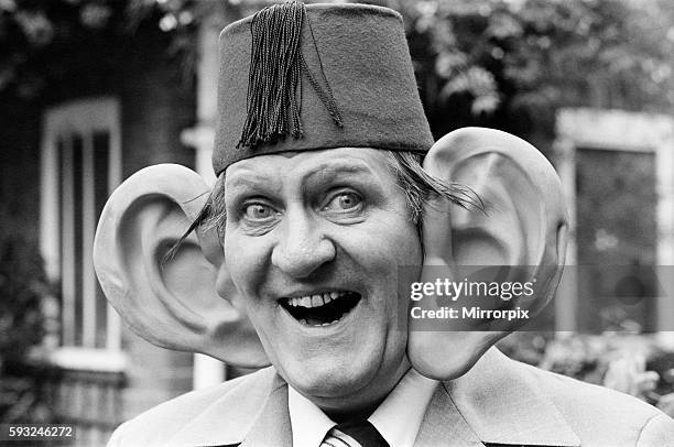 British prop comedian and magician Tommy Cooper, 15th July 1977. Pictured wearing a giant pair of ears, which he will be using as a prop when guest...
