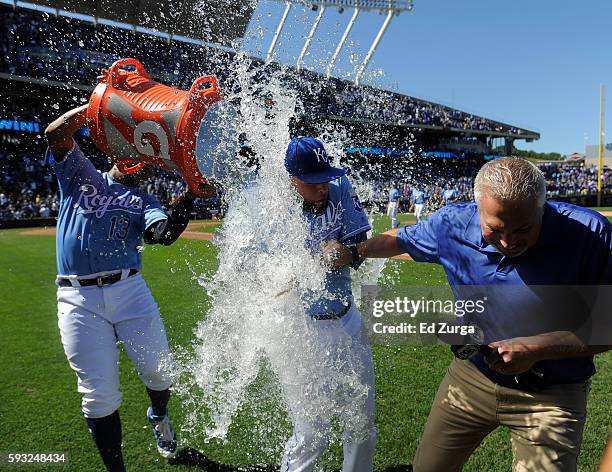 Kelvin Herrera of the Kansas City Royals and Fox Sports Kansas City announcer Joel Goldberg are doused with water by Salvador Perez of the Kansas...